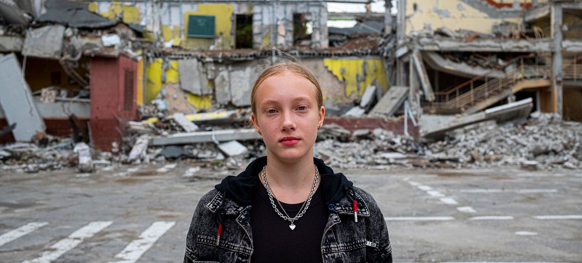 Ukrayna'nın Kharkiv kentindeki çatışmalar sırasında bir hava saldırısında yıkılan okulunun önünde on iki yaşında bir kız çocuğu duruyor.