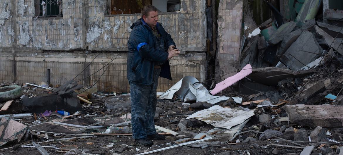 A man removes debris around a residential building in Kyiv, Ukraine. A man removes debris around a residential building in Kyiv, Ukraine.