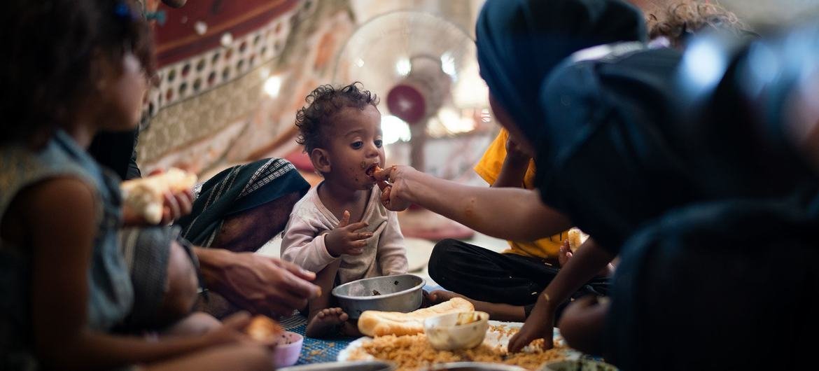 A one-year-old boy eats with his family in a displaced persons camp in Aden, Yemen. A one-year-old boy eats with his family in a displaced persons camp in Aden, Yemen.