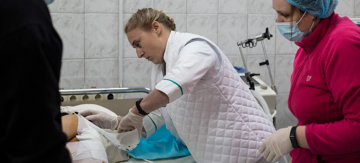A surgeon bandages an injured patient at a Kyiv hospital, Ukraine.