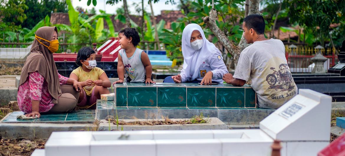 A family visit the grave of their mother who worked at a popular restaurant in Indonesia where she likely contracted COVID-19. A family visit the grave of their mother who worked at a popular restaurant in Indonesia where she likely contracted COVID-19.