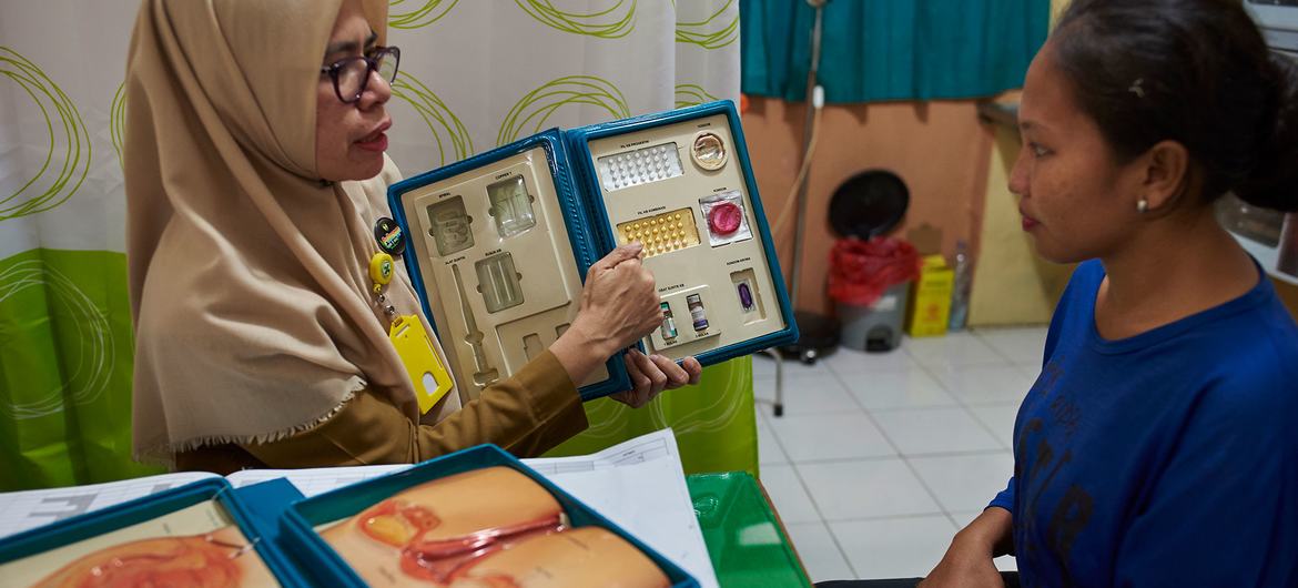 A female counselor shows a woman birth control options at health centre in South Sulawesi, Indonesia. A female counselor shows a woman birth control options at health centre in South Sulawesi, Indonesia.