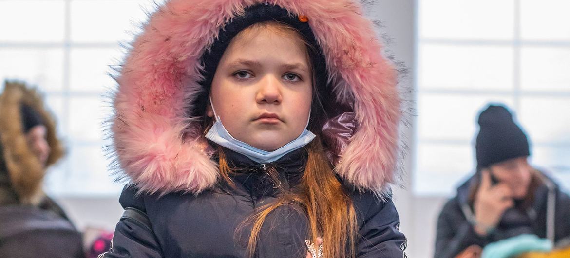 A young Ukrainian girl rests with her dog after arriving in Medyka, Poland with her family.