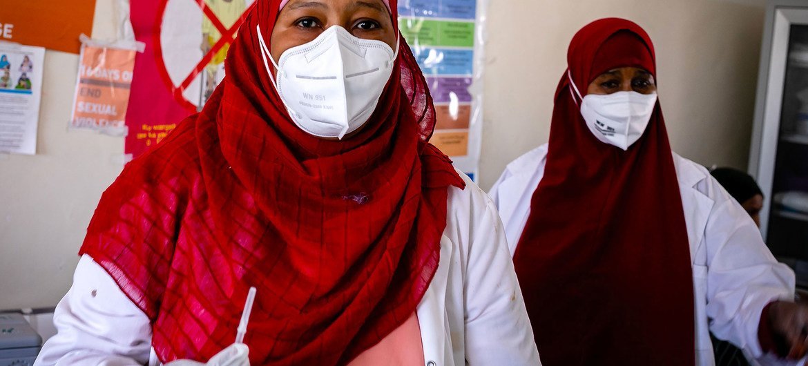A health worker prepares to administer the COVID-19 vaccine to her colleague at a hospital in Mogadishu, Somalia. A health worker prepares to administer the COVID-19 vaccine to her colleague at a hospital in Mogadishu, Somalia.