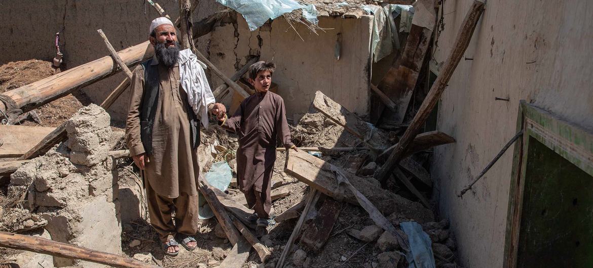 A father and son walk amidst the wreckage of their home, destroyed during the earthquake whick struck Paktika Province, Afghanistan. A father and son walk amidst the wreckage of their home, destroyed during the earthquake whick struck Paktika Province, Afghanistan.