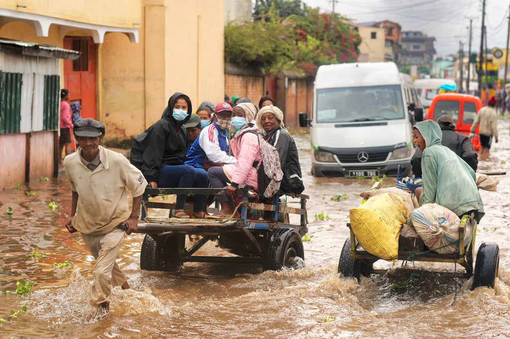 A man transports people on a cart on the flooded main road in Ilanivato district, Antananarivo. Madagascar. A man transports people on a cart on the flooded main road in Ilanivato district, Antananarivo. Madagascar.