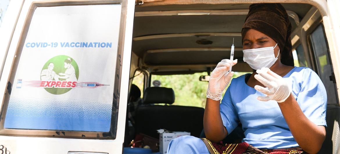 Bir sağlık çalışanı, Malavi, Kasungu'daki bir köyde COVID-19 aşılarını uygulamaya hazırlanıyor.