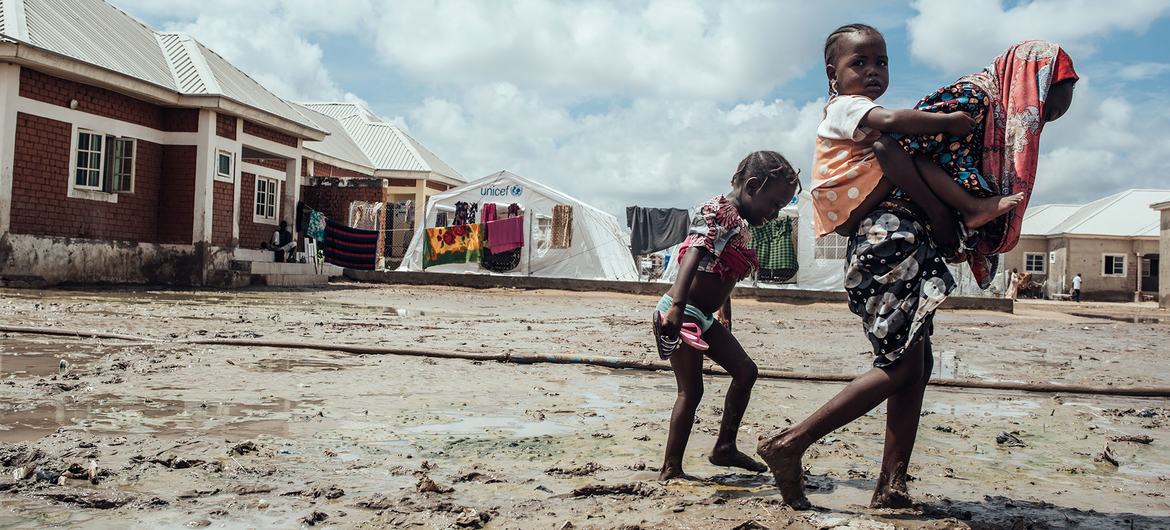 Children walk through mud in a migrant camp in Maiduguri, northeast Nigeria.