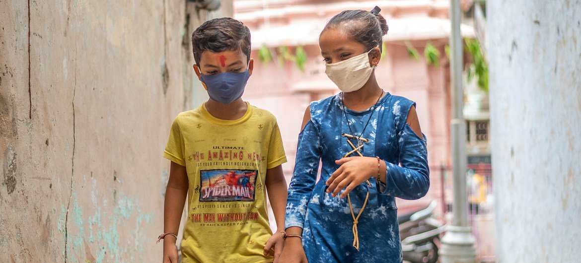 A young boy and girl in India protect themselves against COVID-19 by wearing face masks. A young boy and girl in India protect themselves against COVID-19 by wearing face masks.