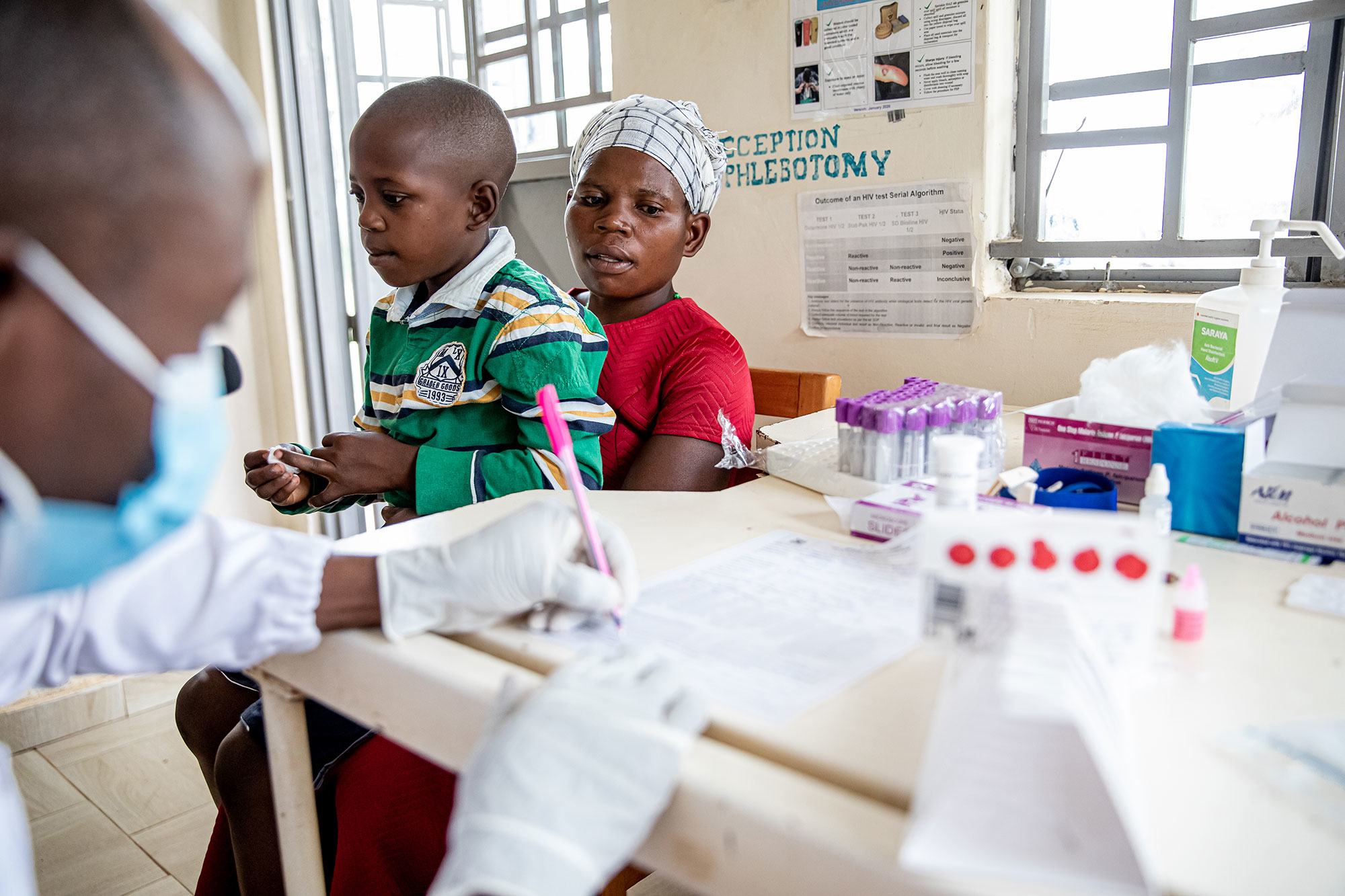 A mother and her nine-year-old son, both HIV-positive, visit a health clinic in in Mubende, Uganda.