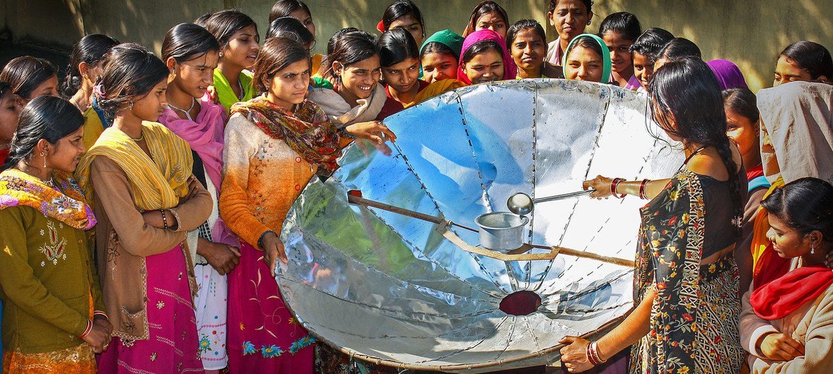 In India, a woman demonstrates how to use a solar dish for cooking. In India, a woman demonstrates how to use a solar dish for cooking.