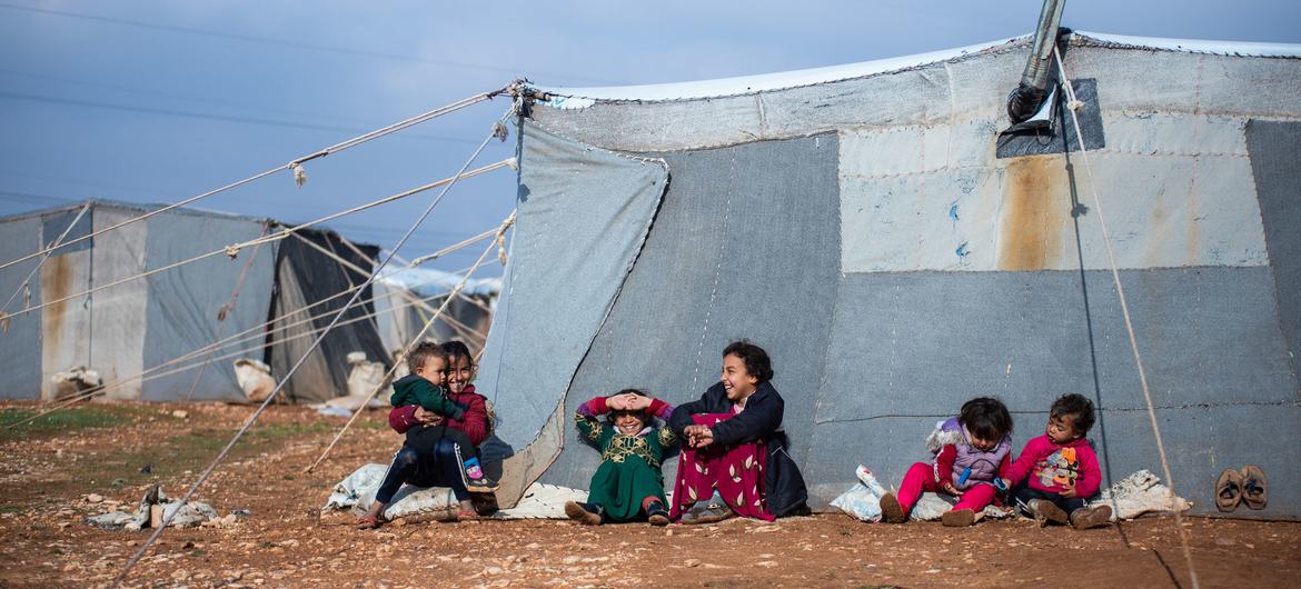 Children sit outside their family tent at the Alzhouriyeh makeshift camp in east rural Homs, Syria. Children sit outside their family tent at the Alzhouriyeh makeshift camp in east rural Homs, Syria.