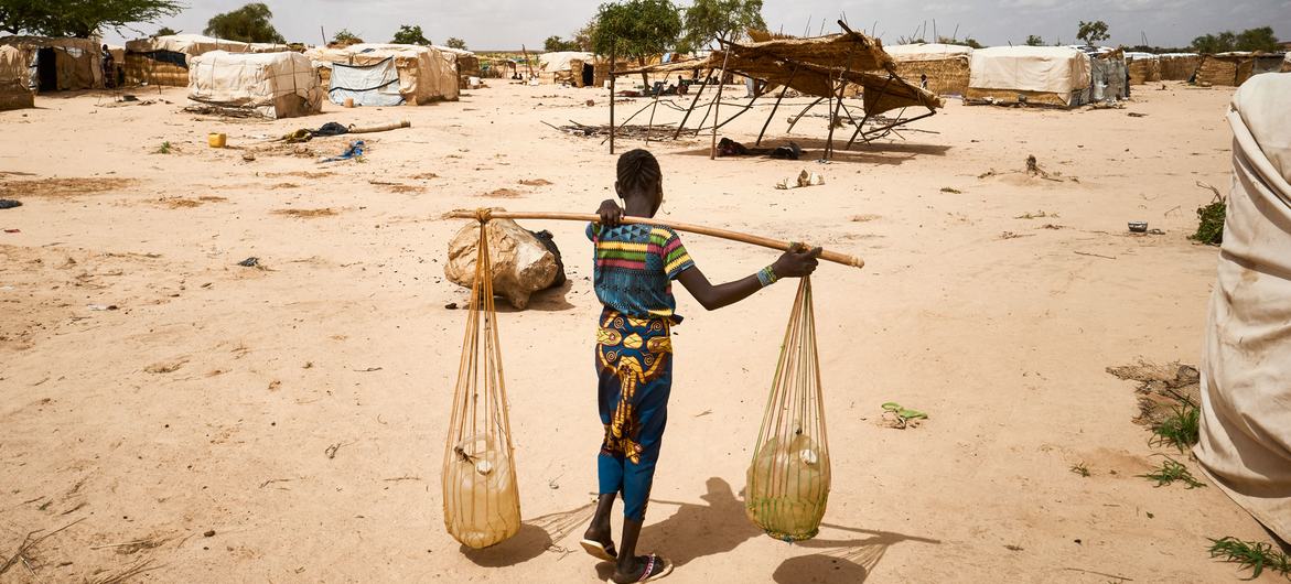A young woman carries water in a camp for displaced people in Tillaberi region, Niger. A young woman carries water in a camp for displaced people in Tillaberi region, Niger.