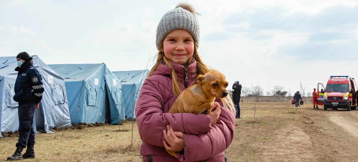 A refugee child from Ukraine stands with her dog at a temporary refugee centre near the Palanca crossing point on the border of the Republic of Moldova and Ukraine, on 26 February 2022. A refugee child from Ukraine stands with her dog at a temporary refugee centre near the Palanca crossing point on the border of the Republic of Moldova and Ukraine, on 26 February 2022.