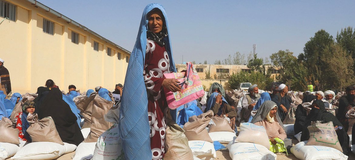 People receive food rations at a WFP distribution site on the outskirts of Herat in Afghanistan. People receive food rations at a WFP distribution site on the outskirts of Herat in Afghanistan.
