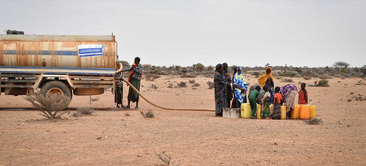 A group of women fetch water at a water trucking point in Kureyson village, Galkayo, Somalia on 23 March 2022. A group of women fetch water at a water trucking point in Kureyson village, Galkayo, Somalia on 23 March 2022.