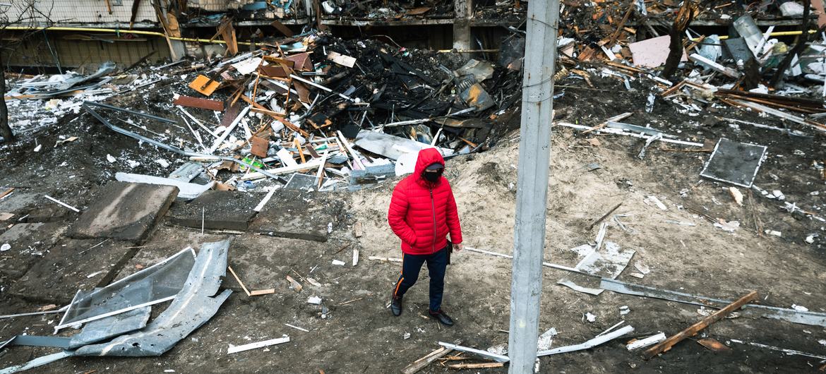 A man walks in front of a crater left by an explosion during the escalating conflict in Kyiv, Ukraine.  