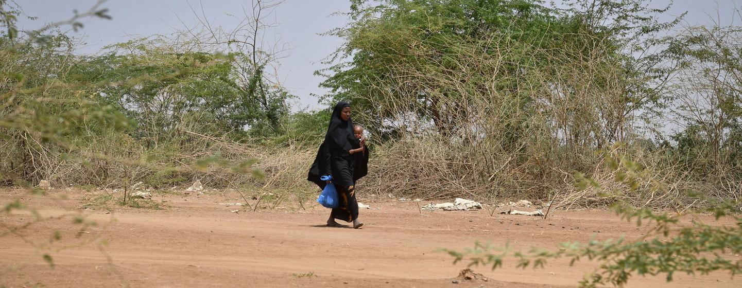 A mother and her child pass by carcasses of goats and sheep in Luuq, Somalia on 21 March 2022. A mother and her child pass by carcasses of goats and sheep in Luuq, Somalia on 21 March 2022.