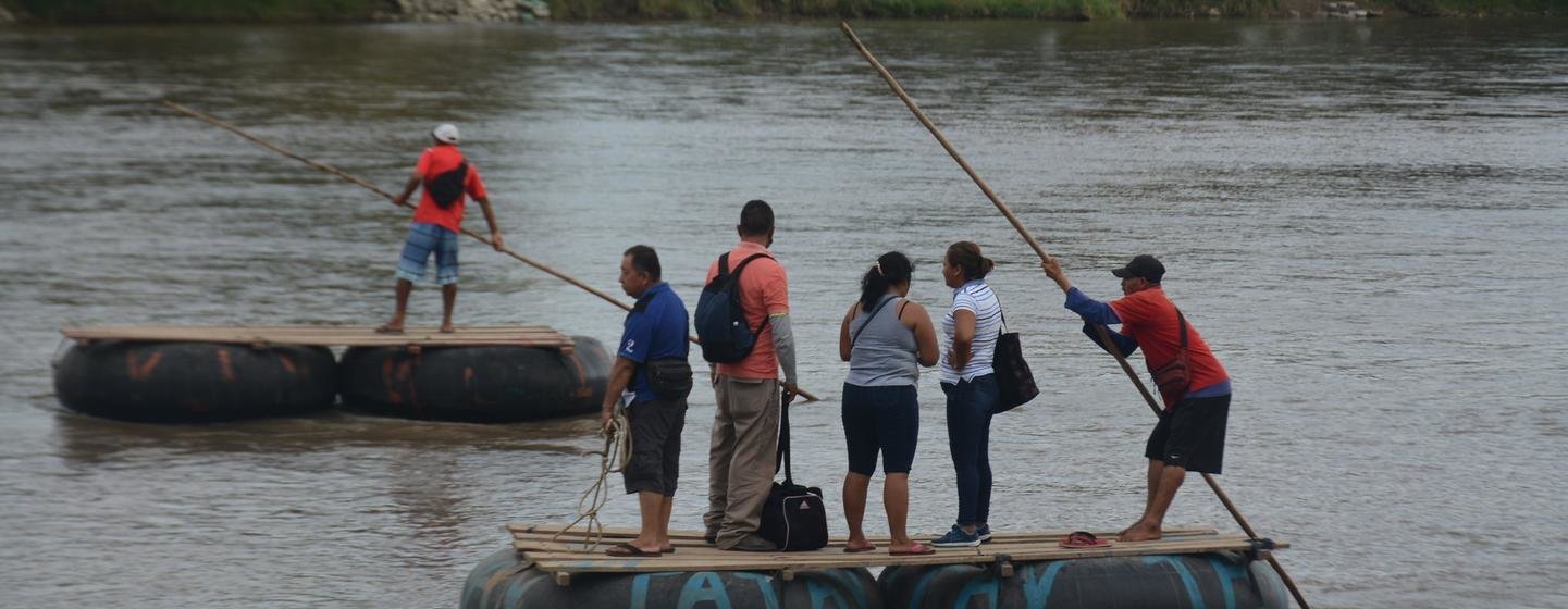A group of people cross the Suchiate River on a raft, crossing the border between Guatemala and Mexico, in November 2021. A group of people cross the Suchiate River on a raft, crossing the border between Guatemala and Mexico, in November 2021.