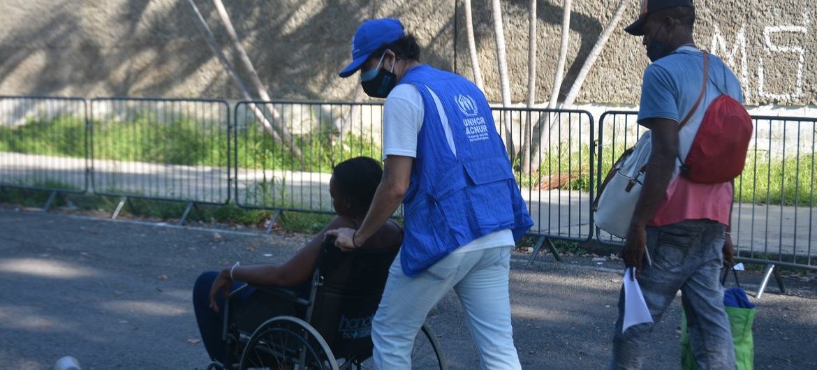 UNHCR staff assist a migrant at the Olympic Stadium in Tapachula, Chiapas, in November 2021. UNHCR staff assist a migrant at the Olympic Stadium in Tapachula, Chiapas, in November 2021.