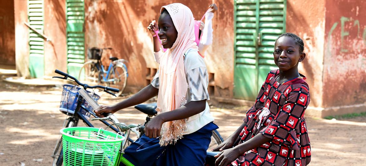 Children ride a bike in Fada, Burkina Faso. Children ride a bike in Fada, Burkina Faso.