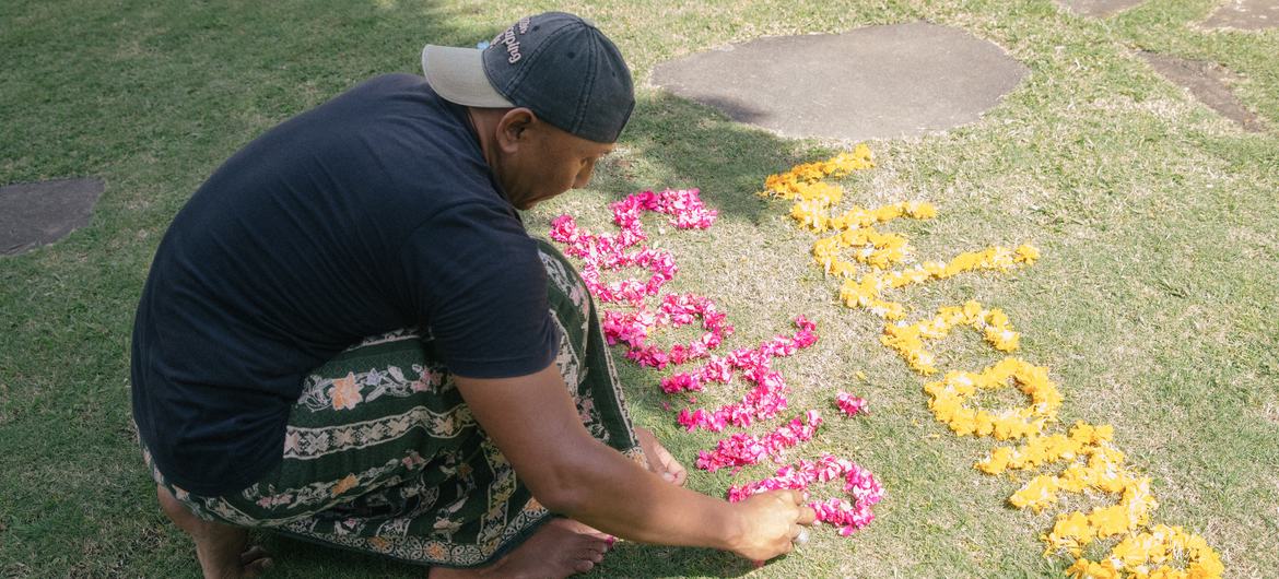 Dekha Dewandana arrange words with flowers at Esa di Kubu Homestay in Sudaji Village, Buleleng, Bali, Indonesia.
