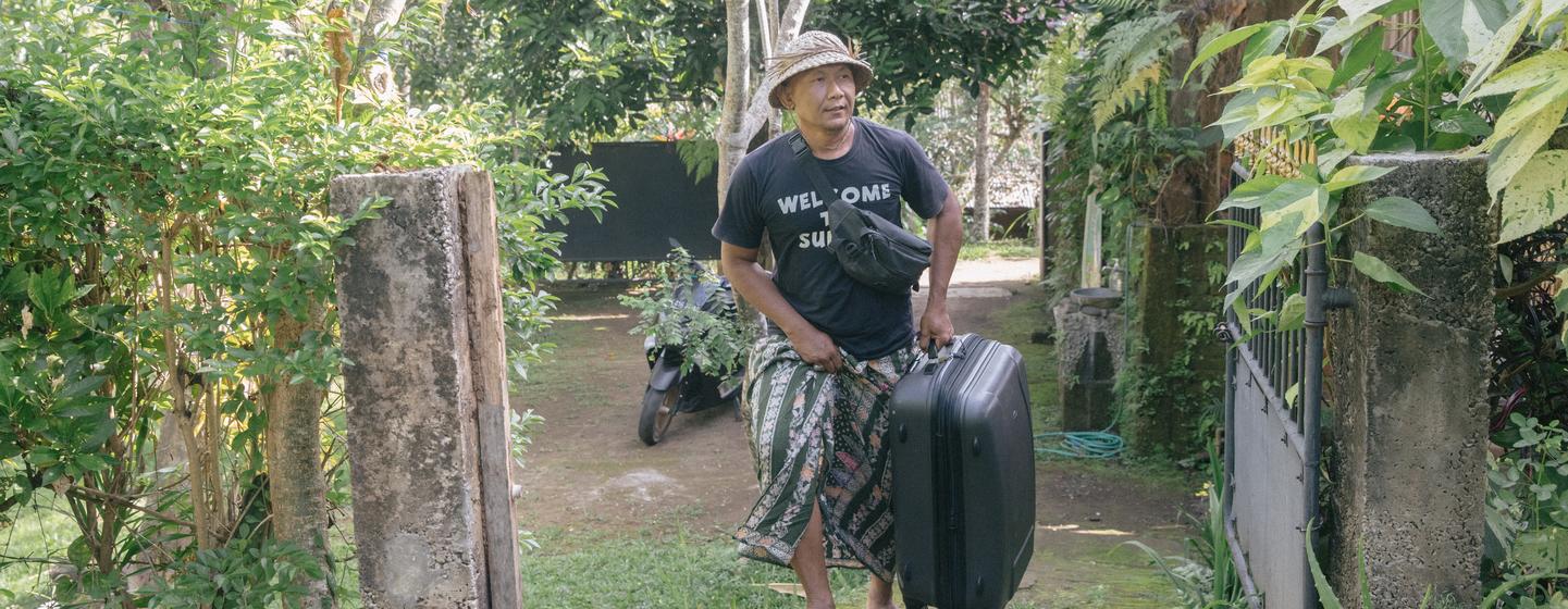 Dekha Dewandana carries his guest suitcase at Esa di Kubu Homestay in Sudaji Village, Buleleng, Bali, Indonesia. Dekha Dewandana carries his guest suitcase at Esa di Kubu Homestay in Sudaji Village, Buleleng, Bali, Indonesia.