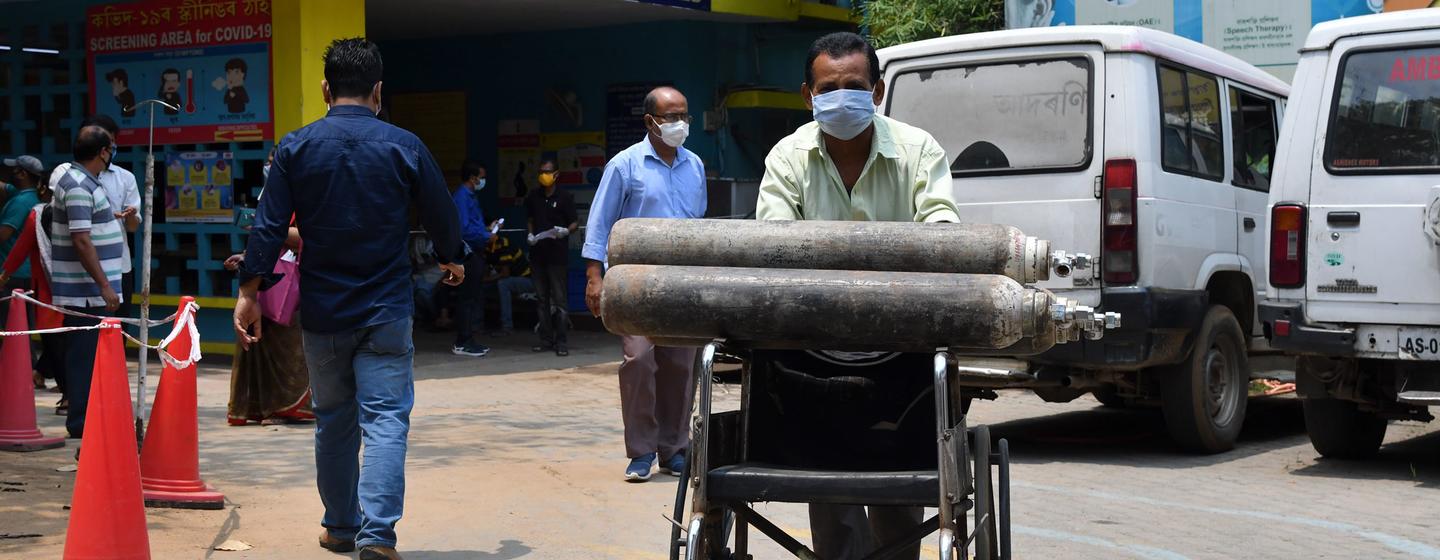 A health worker carries Oxygen cylinders in Guwahati, India. A health worker carries Oxygen cylinders in Guwahati, India.