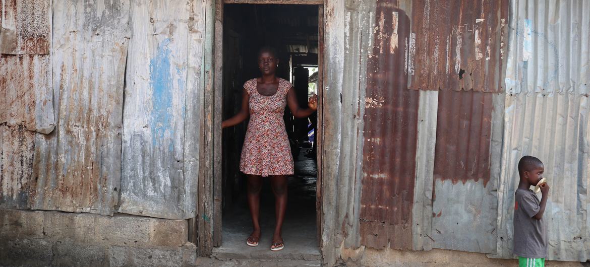 Agnes-Josephine Kenderman and her son stand infront of her house in Liberia.