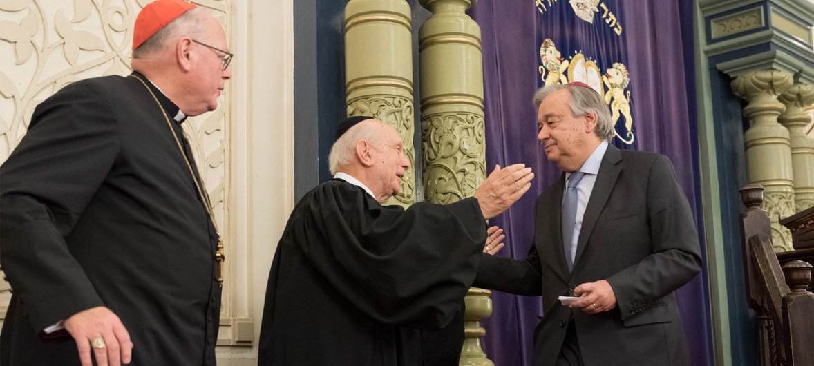 Secretary-General António Guterres (right) is greeted by Arthur Schneier, Senior Rabbi at Park East Synagogue, alongside Cardinal Timothy Dolan, at a 2018 interfaith ceremony following the deadly mass shooting at the Tree of Life synagogue in Pittsburgh. Secretary-General António Guterres (right) is greeted by Arthur Schneier, Senior Rabbi at Park East Synagogue, alongside Cardinal Timothy Dolan, at a 2018 interfaith ceremony following the deadly mass shooting at the Tree of Life synagogue in Pittsburgh.