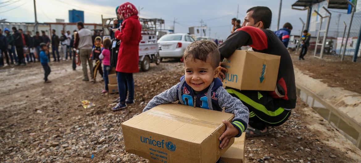 A three-year-old boy sits on a box of winter clothing that his family has received from a distribution at Kawergosk Syrian Refugee Camp in Erbil Governorate in the Kurdistan region of Iraq. A three-year-old boy sits on a box of winter clothing that his family has received from a distribution at Kawergosk Syrian Refugee Camp in Erbil Governorate in the Kurdistan region of Iraq.