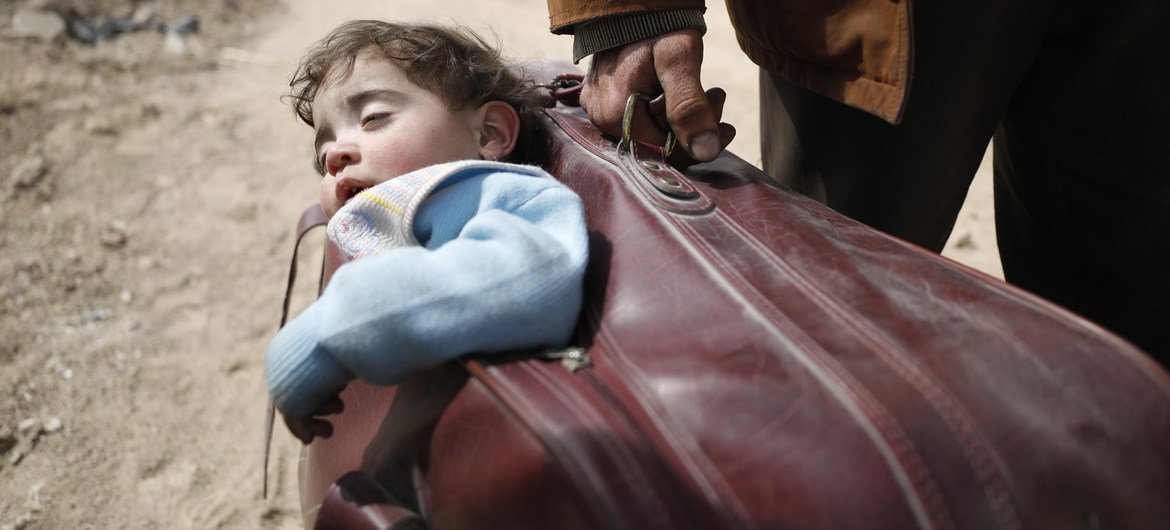 A man carried a child in his suitcase as he fled eastern Ghouta in 2018. A man carried a child in his suitcase as he fled eastern Ghouta in 2018.